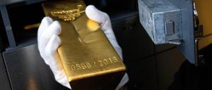 Ein Mann legt beim Edelmetallhändler Pro Aurum einen Goldbarren in ein Schließfach in einem Tresorraum. 
