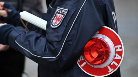 Ein Polizist trägt eine Polizeikelle.