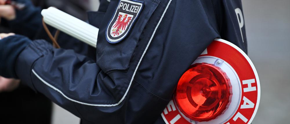 Ein Polizist trägt eine Polizeikelle.