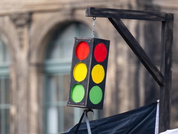 In Dresden steht auf einem Protestzug eine Ampel am Galgen.