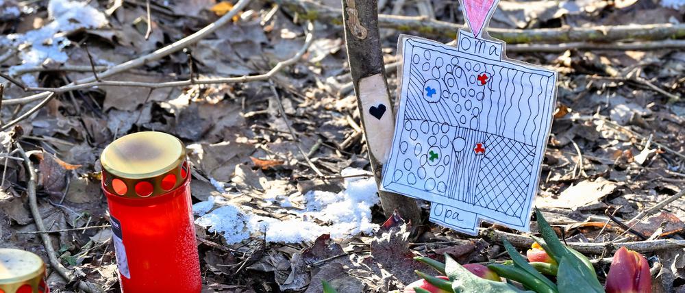 08.01.2024, Brandenburg, Wilmersdorf: An der Stelle eines Unfalls mit zwei Toten an einer Straße im Wald sind Kerzen, Blumen, ein Holzkreuz und eine kleine Zeichnung mit der Aufschrift «Oma, Opa» zu sehen. Bei den zwei Toten eines Verkehrsunfalls vom vergangenen Dienstag (02.01.2024) bei Briesen (Oder-Spree) handelt es sich um einen Brandenburger Künstler und seine Frau. Das bestätigte ein Sprecher des Brandenburgischen Landesmuseums für Moderne Kunst am Montag der Deutschen Presse-Agentur. Foto: Patrick Pleul/dpa +++ dpa-Bildfunk +++