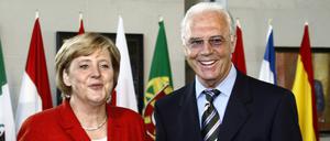Bundeskanzlerin Angela Merkel 2006 in Berlin mit dem WM-Endspielball in der Hand neben WM-OK-Chef Franz Beckenbauer. 