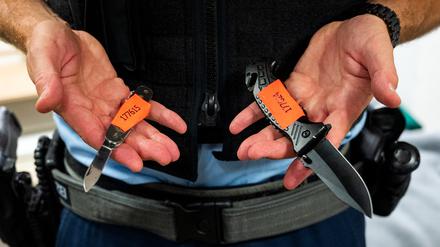 Ein Bundespolizist zeigt sichergestellte Messer.