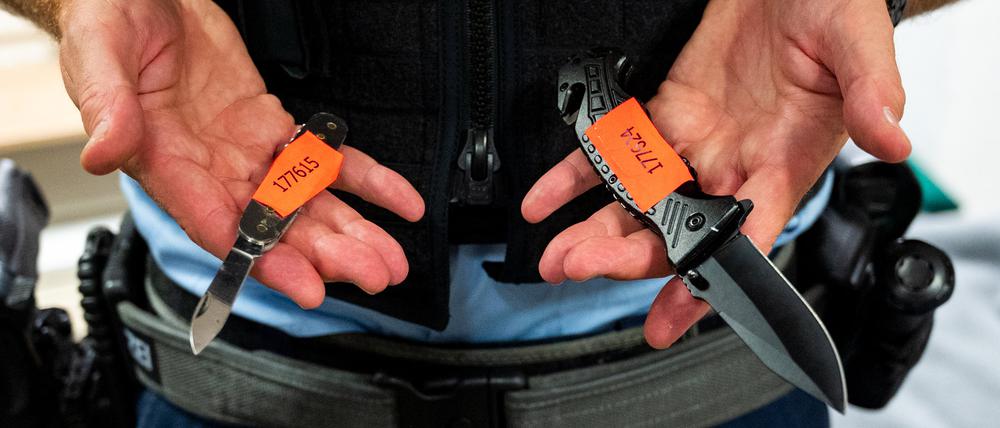 Ein Bundespolizist zeigt sichergestellte Messer.