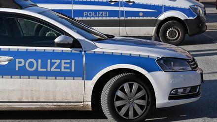 Zwei Polizeiwagen stehen geparkt auf einem Parkplatz.