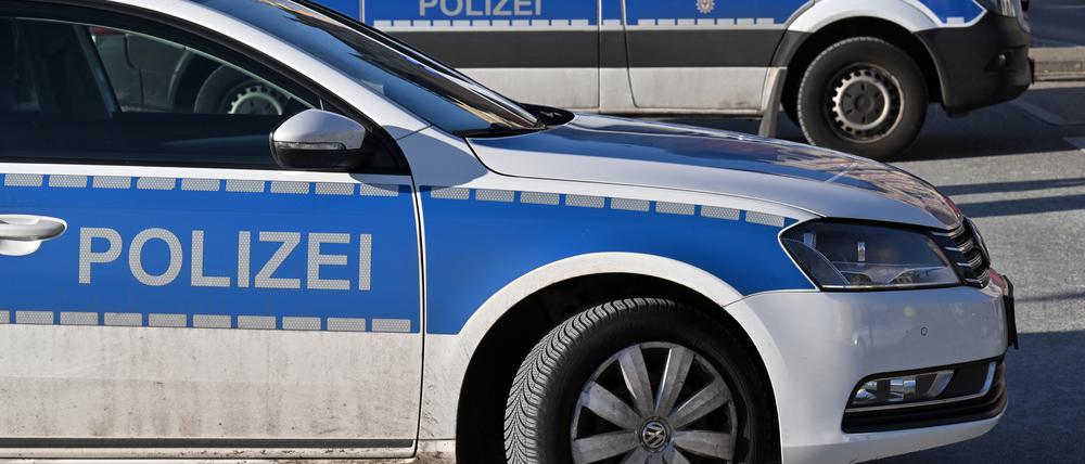 Zwei Polizeiwagen stehen geparkt auf einem Parkplatz.