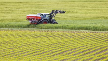 Landwirt beim Düngen seiner Felder mit dem Traktor.