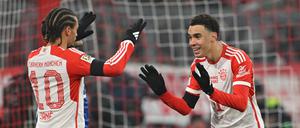 Münchens Torschütze Jamal Musiala (r) jubelt mit Leroy Sane nach dem Tor zum 2:0.