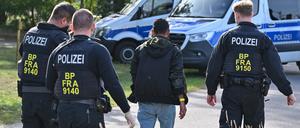 Ein unerlaubt eingereister Migrant wird durch Beamte der Bundespolizei nahe Forst (Lausitz) zum Fahrzeug geführt.