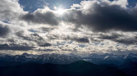 Die Sonne scheint hinter den dunklen Wolken.