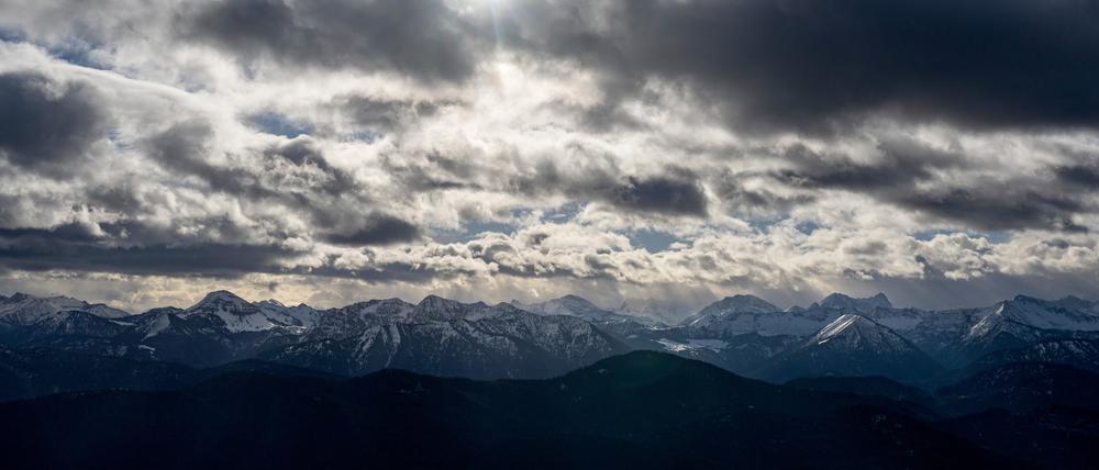 Die Sonne scheint hinter den dunklen Wolken.