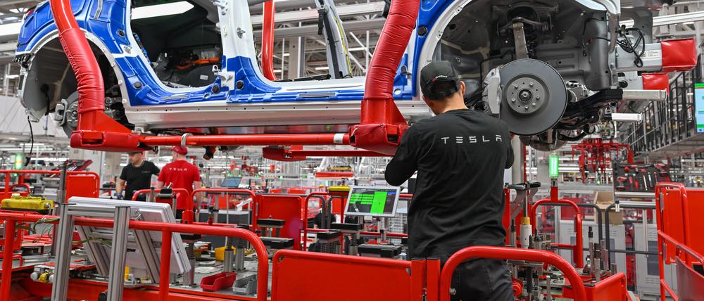 Ein Mitarbeiter der Tesla Gigafactory Berlin Brandenburg arbeitet an einer Fertigungslinie eines Elektrofahrzeuges vom Typ Model Y.