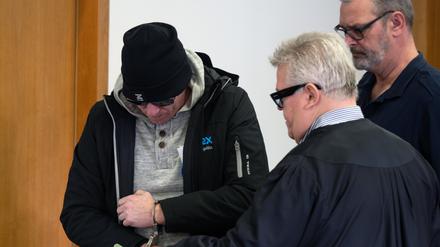 Einer der beiden Angeklagten (l) kommt vor Beginn der Hauptverhandlung in den Gerichtssaal 8 des Potsdamer Landgerichts. 