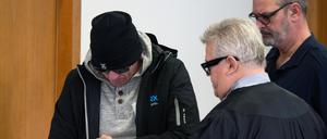 Einer der beiden Angeklagten (l) kommt vor Beginn der Hauptverhandlung in den Gerichtssaal 8 des Potsdamer Landgerichts. 