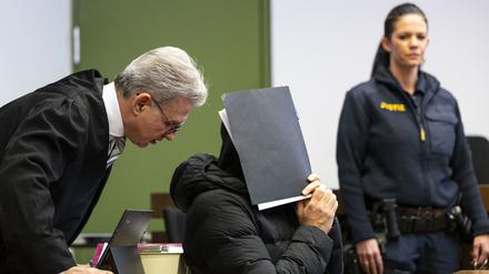 Der wegen sexuellen Missbrauchs angeklagte Fußballtrainer (M) unterhält sich zum Prozessauftakt im Gerichtssaal des Landgerichts mit seinem Rechtsanwalt Peter Guttmann.