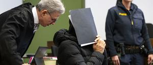 Der wegen sexuellen Missbrauchs angeklagte Fußballtrainer (M) unterhält sich zum Prozessauftakt im Gerichtssaal des Landgerichts mit seinem Rechtsanwalt Peter Guttmann.