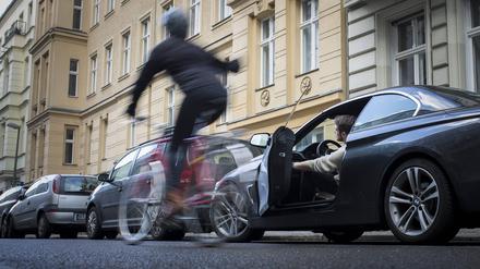 Gestellte Szene zum Thema Verkehrssicherheit: Ein Autofahrer oeffnet die Fahrertuer, waehrend ein Radfahrer eng daran vorbeifaehrt und sich darueber aufregt. Berlin, 13.02.2018. Berlin Deutschland *** Asked scene on the subject of road safety a motorist opens the driver s door while a cyclist closely passes by and it upset Berlin 13 02 2018 Berlin Germany PUBLICATIONxINxGERxSUIxAUTxONLY Copyright: xFlorianxGaertner/photothek.netx  