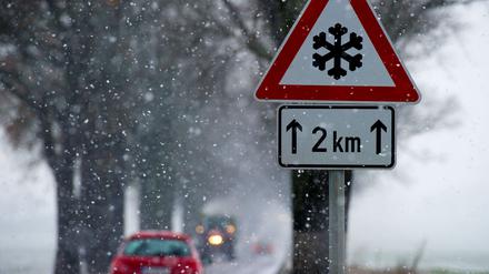 Ein Warnschild für Winterglätte am 06.12.2012 im Schneefall an einer Allee nahe Seelow (Brandenburg). In weiten Teilen von Brandenburg kam es am gleichen Tag zu vielen witterungsbedingten Unfällen. Foto: Patrick Pleul/ZB +++(c) ZB-FUNKREGIO OST - Honorarfrei nur für Bezieher des ZB-Regiodienstes+++