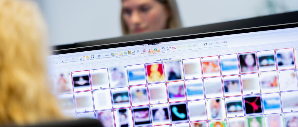 Ermittlerinnen sitzen vor Monitoren mit unkenntlich gemachten Fotografien, die teilweise sexuellen Missbrauch zeigen.