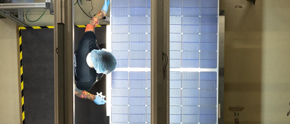 Eine Mitarbeiterin steht bei der Qualitätskontrolle an einer Produktionslinie für Solarmodule im Werk der Meyer Burger Technology AG.