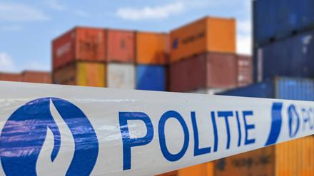 Eine Polizeibandabsperrung vor beschlagnahmten Contaionern in Belgien.
