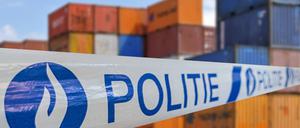 Eine Polizeibandabsperrung vor beschlagnahmten Contaionern in Belgien.