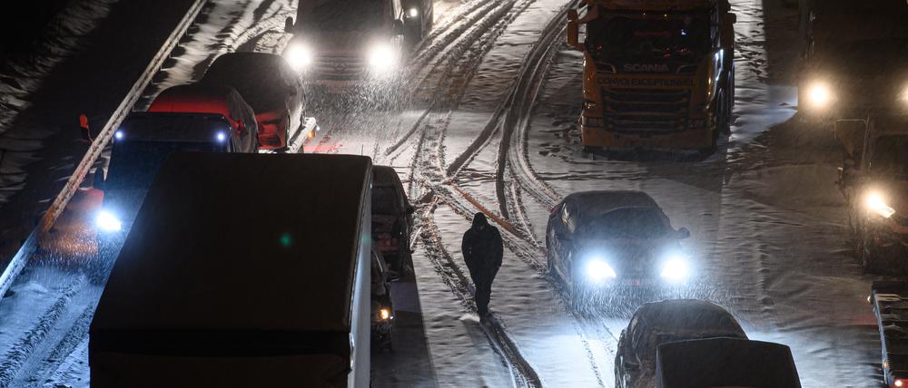 Autos und Lastwagen stehen am frühen Morgen bei Schneefall auf der verschneiten Autobahn 4 bei Dresden im Stau (Archivbild vom 08.02.2021).