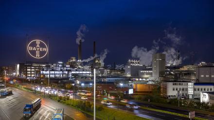 Das Bayer-Kreuz, das Logo des Unternehmens, leuchtet auf dem Werksgelände von Bayer in Leverkusen. Der Umbau des Agrarchemie- und Pharmakonzerns Bayer wird wohl viele Mitarbeiter den Job kosten.