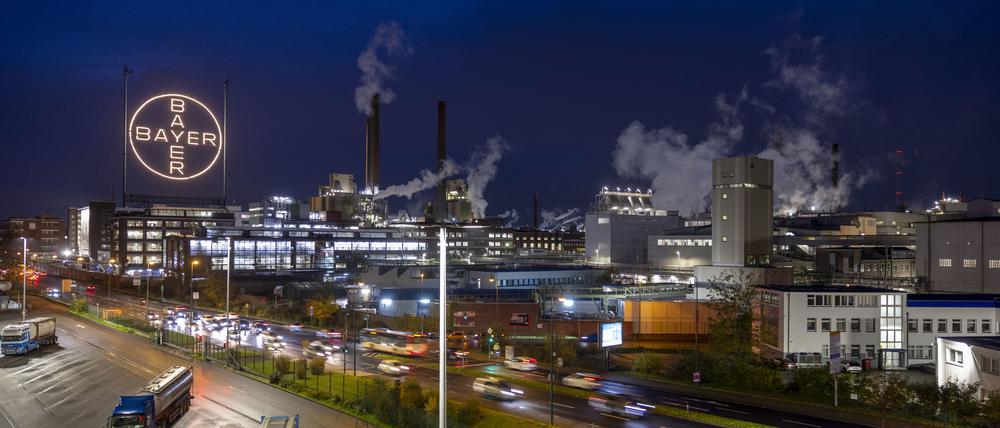 Das Bayer-Kreuz, das Logo des Unternehmens, leuchtet auf dem Werksgelände von Bayer in Leverkusen. Der Umbau des Agrarchemie- und Pharmakonzerns Bayer wird wohl viele Mitarbeiter den Job kosten.