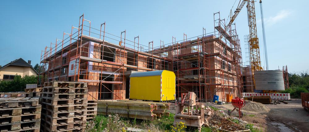 Ein Backsteinhaus ist eingerüstet, ein Kran steht im Hintergrund, doch dieses Bild ist inzwischen zu einer Seltenheit geworden. Die Zahl der Baugenehmigungen sind zuletzt um 17 Prozent gefallen – trotz eklatanten Wohnungsmangels.