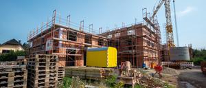 Ein Backsteinhaus ist eingerüstet, ein Kran steht im Hintergrund, doch dieses Bild ist inzwischen zu einer Seltenheit geworden. Die Zahl der Baugenehmigungen sind zuletzt um 17 Prozent gefallen – trotz eklatanten Wohnungsmangels.