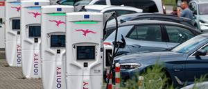 Elektroautos laden an eine Ladestation an einer Autobahnraststätte.