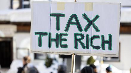 Auf einem Schild steht «Tax the richt». 