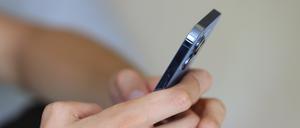 Ein Jugendlicher hält ein Smartphone in den Händen.