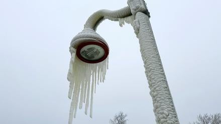 18.01.2024, USA, Paterson: Eiszapfen hängen von einer Laterne.