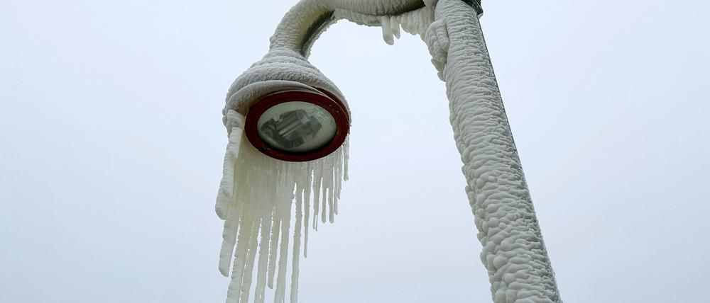 18.01.2024, USA, Paterson: Eiszapfen hängen von einer Laterne.