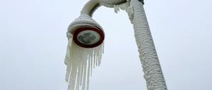 18.01.2024, USA, Paterson: Eiszapfen hängen von einer Laterne.