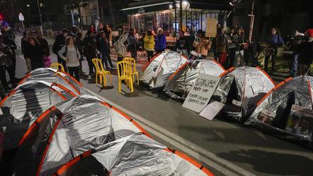 Angehörige und Unterstützer der israelischen Geiseln, die im Gazastreifen von der Hamas festgehalten werden, blockieren eine Straße vor der Residenz des israelischen Premierministers Netanjahu mit Zelten während einer Protestaktion für die Freilassung der Geiseln.