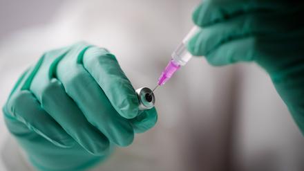 Eine Mitarbeiterin zieht im Corona-Impfbus in Berlin-Mitte eine Spritze mit einem Corona-Impfstoff auf.