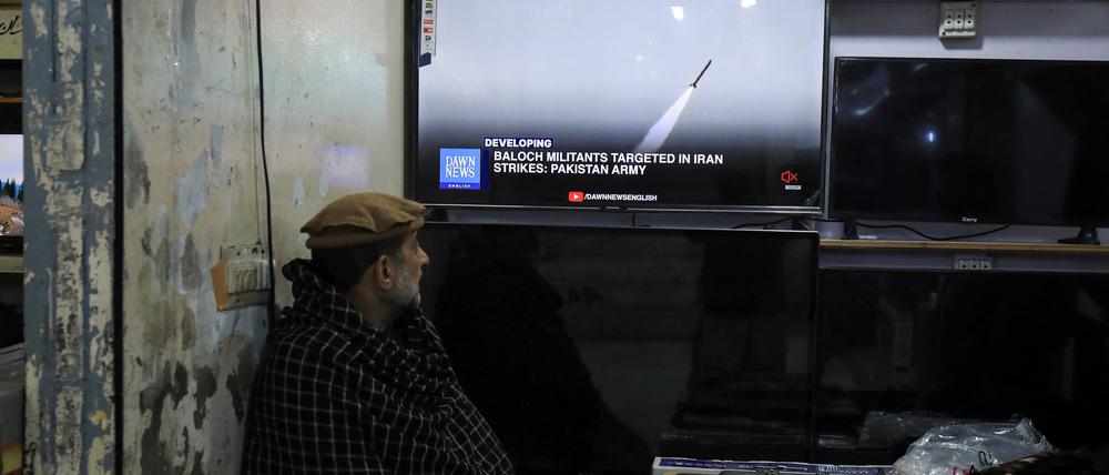 Ein Mann in Pakistan verfolgt auf einem Fernseher die Berichterstattung über die Raketenangriffe.
