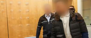 Der Angeklagte (vorne) kommt hinter einer Glasscheibe in den Düsseldorfer Gerichtssaal. Der 42-Jährige soll 2013 eine führende Position beim IS in Syrien eingenommen haben. 