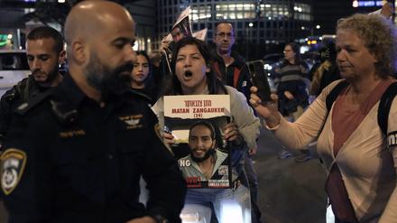 Demonstranten versuchen, eine Straße zu blockieren, während sie Schilder halten, auf denen sie die Freilassung der israelischen Geiseln fordern.