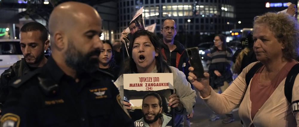Demonstranten versuchen, eine Straße zu blockieren, während sie Schilder halten, auf denen sie die Freilassung der israelischen Geiseln fordern.