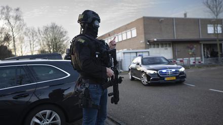 Maskierte und bewaffnete niederländische Polizisten bewachen einen Transport mit einigen der Verdächtigen, die vor dem Hochsicherheitsgebäude des Gerichts in Amsterdam eintreffen.