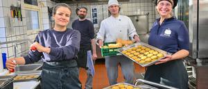 PRODUKTION - 09.01.2024, Brandenburg, Biesenthal: Franziska Ernst (l) und Annette Schmidt, beide leiten die Wukantina, stehen zusammen mit dem Koch Oliver Kahlenbach und dem Praktikanten Fabian Sliwa (2.v.r.) in der Küche und fertigen Erbsen-Möhren-Frittata. Die Wukantina ist ein kulinarischer Kollektivbetrieb für Catering im Landkreis Barnim. Das Unternehmen versorgt Schulen und Kindergärten sowie Veranstaltungen mit Mahlzeiten aus frischen, möglichst regionalen und saisonalen Zutaten. (zu dpa: ««Wukantina» - Wie geht gesundes Essen für Kinder?») Foto: Patrick Pleul/dpa +++ dpa-Bildfunk +++