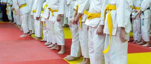 Children in kimono standing on tatami on martial arts training