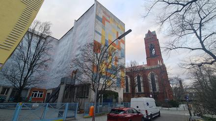 Planen verhängen die Fenster der Schule St. Franziskus, im Hintergrund die St. Matthias-Kiche in Schöneberg.