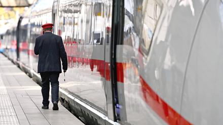 Ein Zugbegleiter an einem ICE an einem Bahnsteig. 