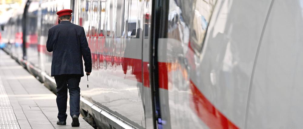 Ein Zugbegleiter an einem ICE an einem Bahnsteig. 