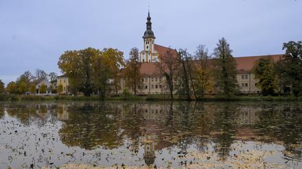 24.10.2022, Brandenburg, Neuzelle: Der Turm der Stiftskirche St. Marien auf dem Gelände vom Zisterzienserkloster Neuzelle und weitere Gebäude des Klosterensembles spiegeln sich im Klosterteich. Foto: Monika Skolimowska/dpa/ZB - Honorarfrei nur für Bezieher des Dienstes ZB-Funkregio Ost +++ ZB-FUNKREGIO OST +++